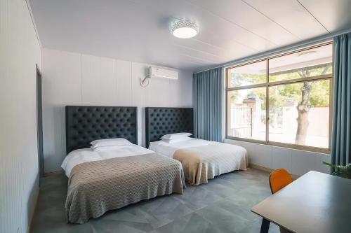 a bedroom with two beds and a window at BVB Holiday Villa - 24h Airport Included in Shanghai