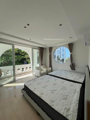 a bedroom with a large bed and large windows at Moon Kê gà hotel in Phan Thiet
