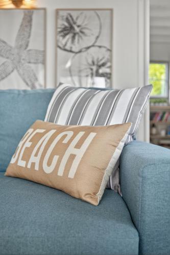 a pillow on a blue couch in a living room at Little Paradis in Beresford