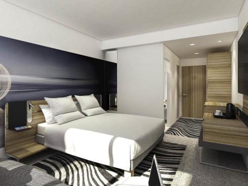 a bedroom with a white bed and a blue wall at Novotel Manchester Centre in Manchester