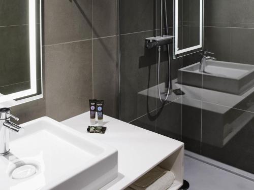 a bathroom with a white sink and a mirror at Novotel Manchester Centre in Manchester