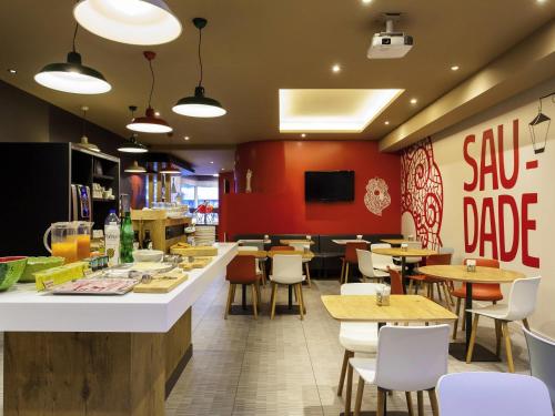 a restaurant with tables and chairs and a bar at Hotel ibis Lisboa Liberdade in Lisbon