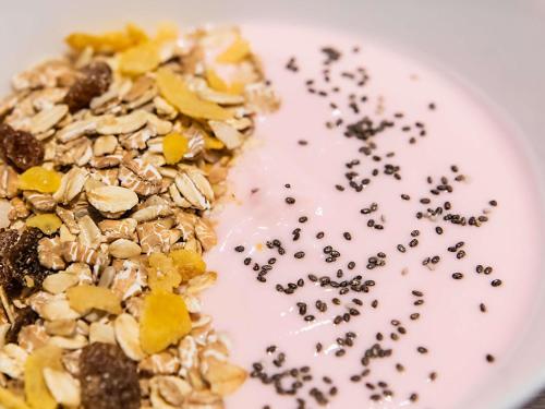 a white plate with granola and a bowl of milk at Hotel ibis Lisboa Liberdade in Lisbon