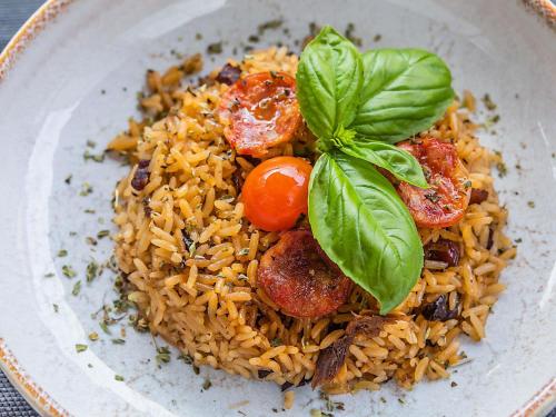 a plate of food with rice and basil on it at Hotel ibis Lisboa Liberdade in Lisbon
