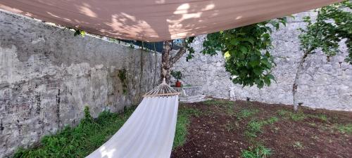 a white hammock in a yard next to a wall at Casa Sofia La Dimora delle Fate in Bagnoli Irpino