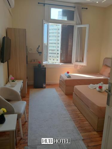 a hotel room with two beds and a large window at Cairo Downtown Hotel in Cairo