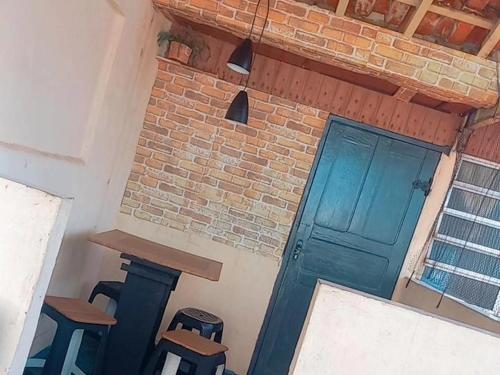 a room with a blue door and some stools at Sobreposta beira praia Lulumar in Itanhaém