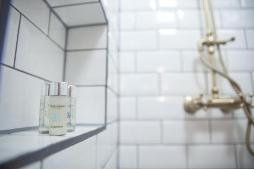 eine Flasche Feuchtigkeitscreme steht auf einem Regal im Badezimmer in der Unterkunft Huge 6 Bedroom House in Central Derby in Derby