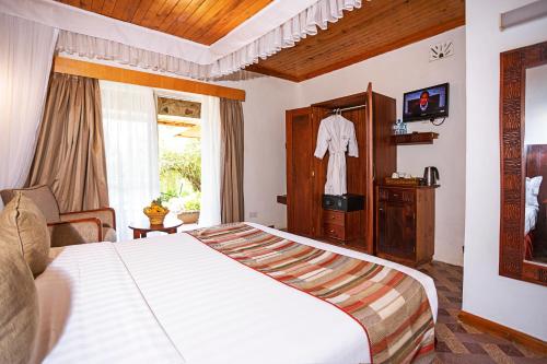 a bedroom with a large white bed and a window at Lake Bogoria Spa Resort in Marigat