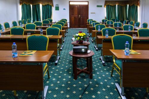 a classroom with desks and chairs and flowers on a table at Lake Bogoria Spa Resort in Marigat