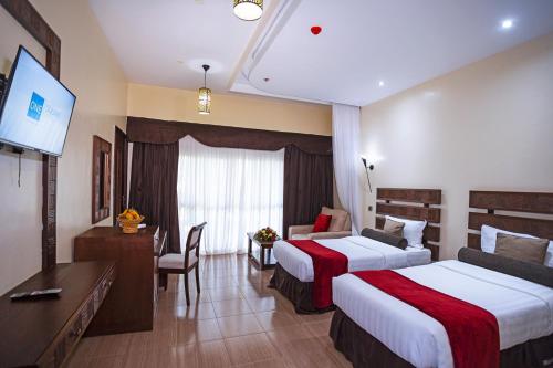 a hotel room with two beds and a desk at Lake Bogoria Spa Resort in Marigat