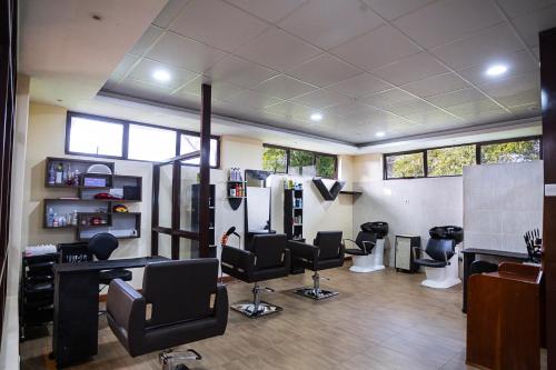 a hair salon with black chairs and tables and windows at Lake Bogoria Spa Resort in Marigat