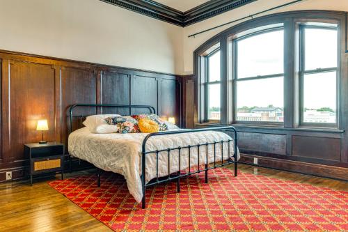 a bedroom with a bed with a red rug at Modern Elegance: Timeless Crawfordsville Studio! in Crawfordsville