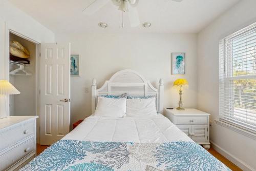 a bedroom with a white bed with a blue and white bedspread at Lofty Views in Indian Pass