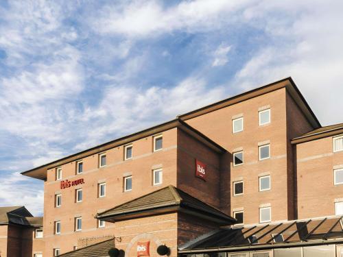 a large brick building with a red sign on it at ibis Liverpool Centre Albert Dock – Liverpool One in Liverpool