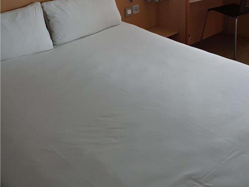a large white bed with white sheets and pillows at ibis Liverpool Centre Albert Dock – Liverpool One in Liverpool