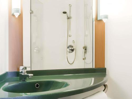 a bathroom with a green sink and a mirror at ibis Liverpool Centre Albert Dock – Liverpool One in Liverpool