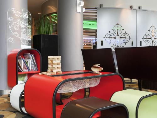 a room with two suitcases and a table and chairs at Novotel Leuven Centrum in Leuven