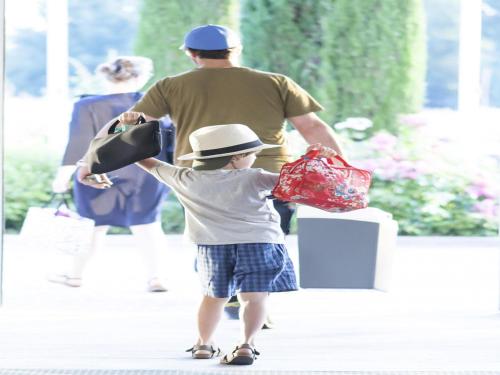 a young boy is holding up a shopping bag at Novotel Leuven Centrum in Leuven