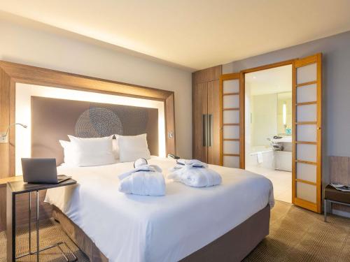 a hotel room with a bed with towels on it at Novotel Mechelen Centrum in Mechelen