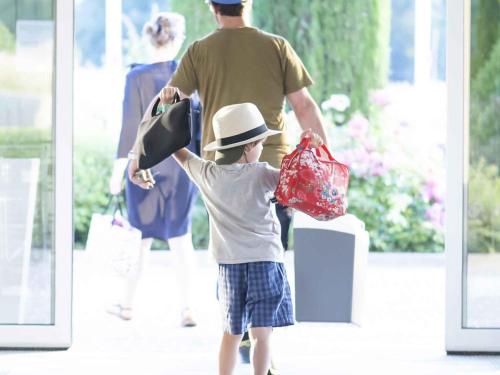 a young boy holding a hat and shopping bags at Novotel Mechelen Centrum in Mechelen
