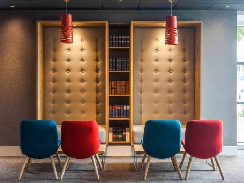 a room with four chairs and a book shelf at ibis London Wembley in London
