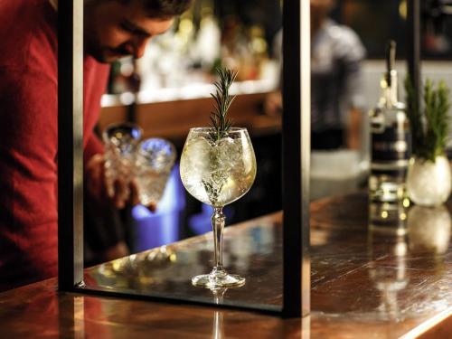 a man standing at a bar with a drink at ibis Manchester Centre 96 Portland Street in Manchester