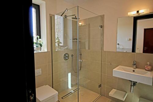a bathroom with a glass shower and a sink at Libertas Cala Llombards Blue Lagoon in Cala Llombards