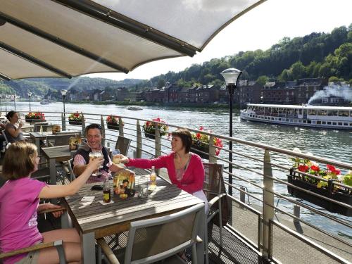 a group of people sitting at a table on a boat at ibis Dinant Centre in Dinant