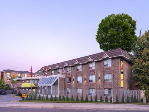 a large brick building on the corner of a street at Super 8 by Wyndham Toronto East ON in Toronto