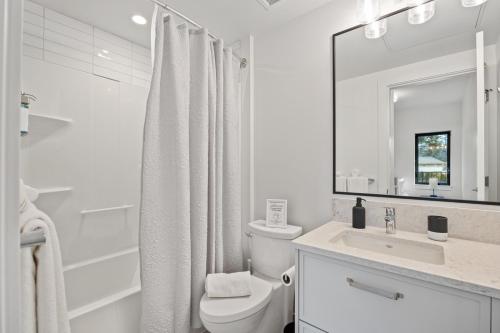 ein weißes Badezimmer mit Toilette und Waschbecken in der Unterkunft Family-Friendly Beachside Bliss in Oyster Bay