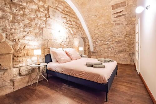 Un dormitorio con una cama en una pared de piedra. en 6 Guests Flat in heart of Paris - Pompidou, en París