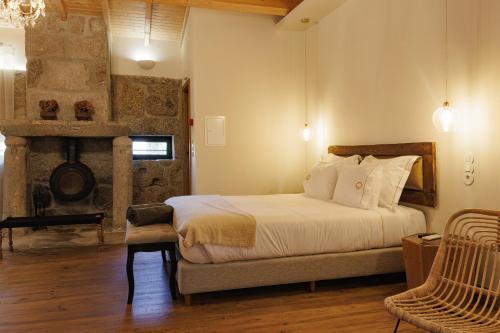 a bedroom with a large bed and a fireplace at Quinta de São Francisco Houses in Viseu
