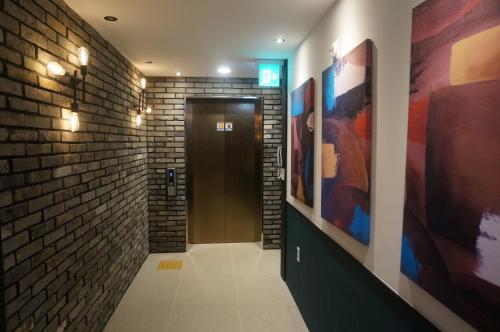 a hallway with a door and a brick wall at MU Hotel in Busan