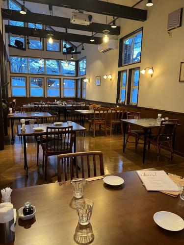 a dining room with tables and chairs and windows at マウンテンリゾート・マルガンタ Marganta in Madarao Kogen