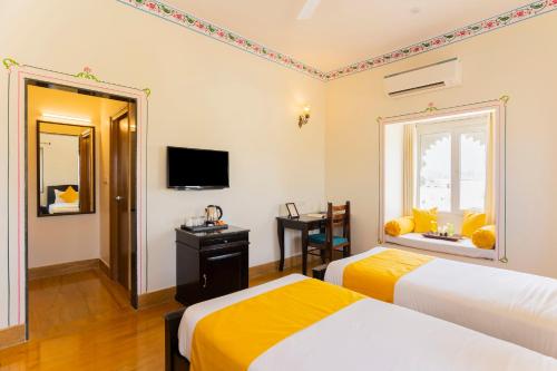 a hotel room with two beds and a window at Vasant Vilas in Udaipur