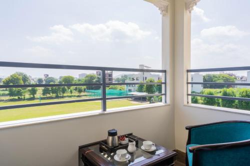 a room with a table and two chairs and a large window at Vasant Vilas in Udaipur