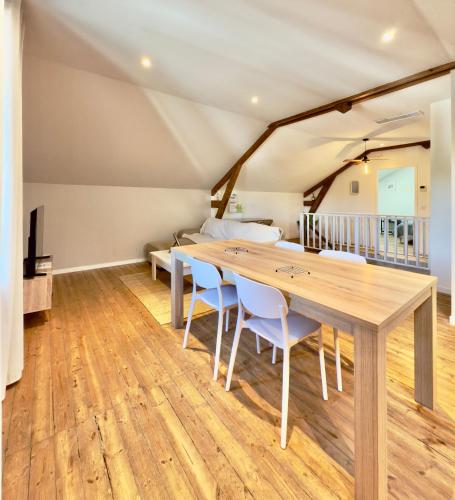 a dining room with a wooden table and chairs at Le Bohème / zone sud - DABNB in Limoges