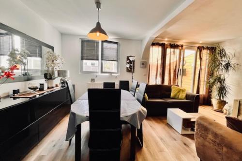 Una cocina y una sala de estar con una mesa y un sofá. en Spacious house in La Rochelle near the beaches, en Vautreuil