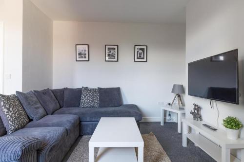 a living room with a blue couch and a tv at Lily Apartment - Sleeps 3 - Pet friendly - Parking in Bedlington