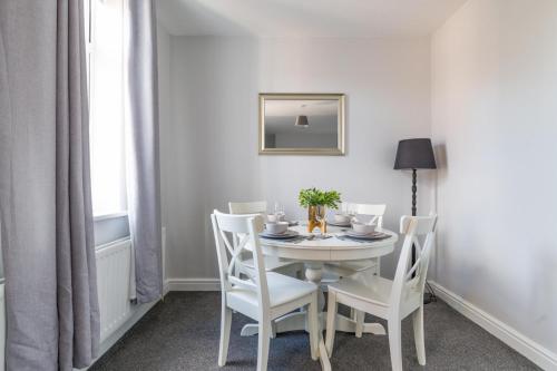 a dining room with a white table and chairs at Lily Apartment - Sleeps 3 - Pet friendly - Parking in Bedlington