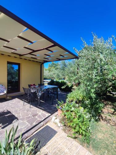 a patio with a table and chairs under a pergola at Casa Vacanze "Dimora Quercia" - Appartamento "Oliva" in Montefalco