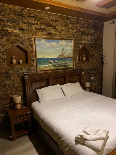 a bedroom with a bed and a painting on the wall at Durrat Nizwa Inn in Nizwa