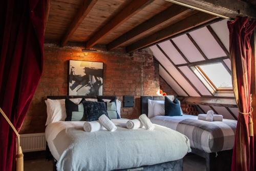 zwei Betten in einem Zimmer mit zwei Fenstern in der Unterkunft Huge 6 Bedroom House in Central Derby in Derby