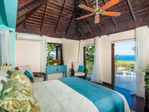 a bedroom with a bed and a ceiling fan at Hospitality Expert HALF HILL Pool Beach in Montego Bay
