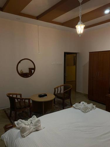 a bedroom with a bed and a table and chairs at Durrat Nizwa Inn in Nizwa