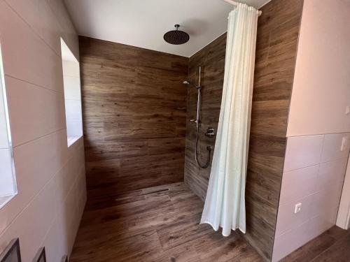 a bathroom with a shower with wooden walls at Apartment Benjamin by Interhome in Hollersbach im Pinzgau