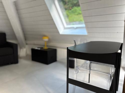 a black chair in a room with a window at Le Tipi - Sauna et Jardin in Esneux