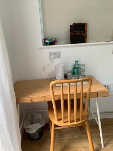 a wooden table with a chair in a room at Garden room with parking in Lewes