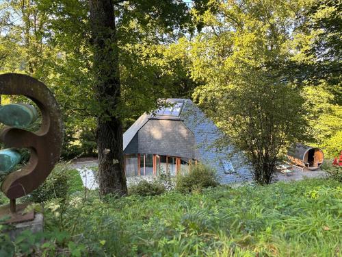 a blue house in the middle of a forest at Le Tipi - Sauna et Jardin in Esneux